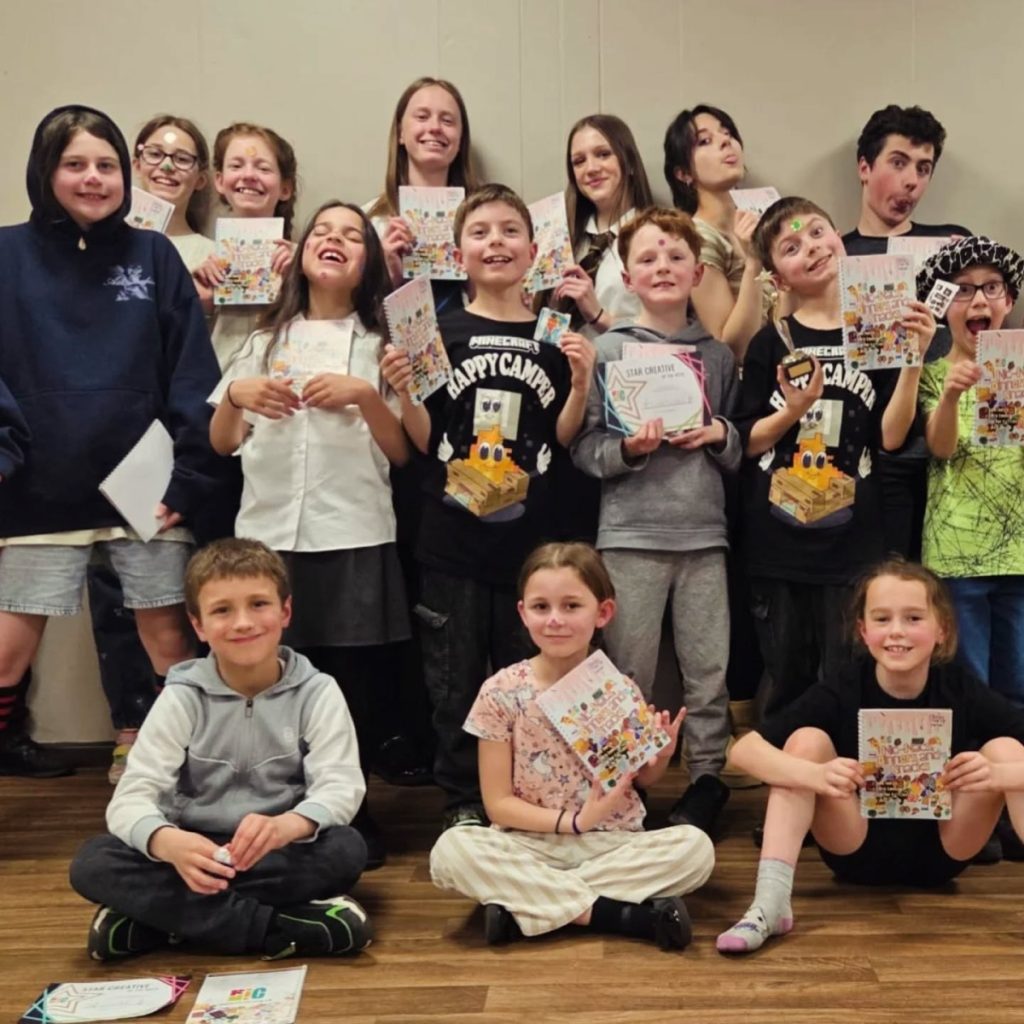 A group of children pose holding their new book